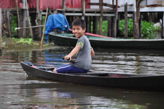 Garoto nos observa durante visita a uma das comunidades ribeirinhas na Reserva do Mamirauá, região de Tefé, no Amazonas